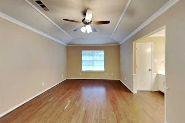 empty room featuring lofted ceiling, hardwood / wood-style flooring, ornamental molding, and ceiling fan