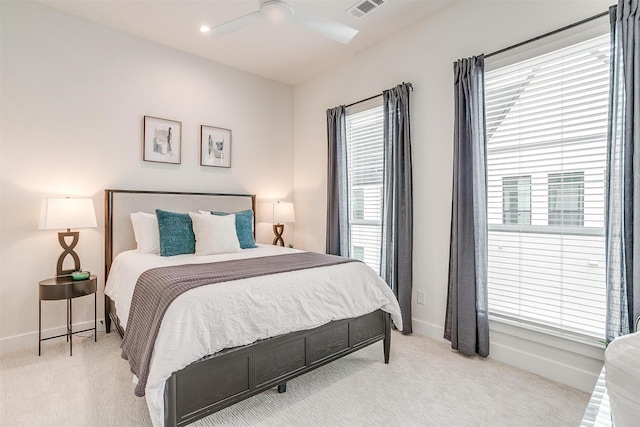 bedroom with multiple windows, light carpet, and ceiling fan