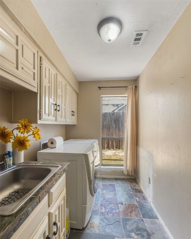 laundry area featuring cabinets, washing machine and dryer, and sink