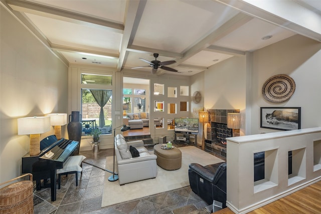 living room featuring ceiling fan, hardwood / wood-style floors, beamed ceiling, and coffered ceiling