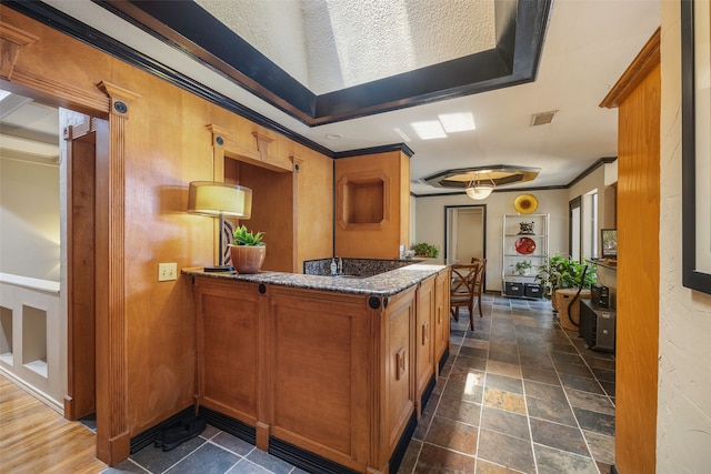 kitchen featuring ornamental molding and stone counters