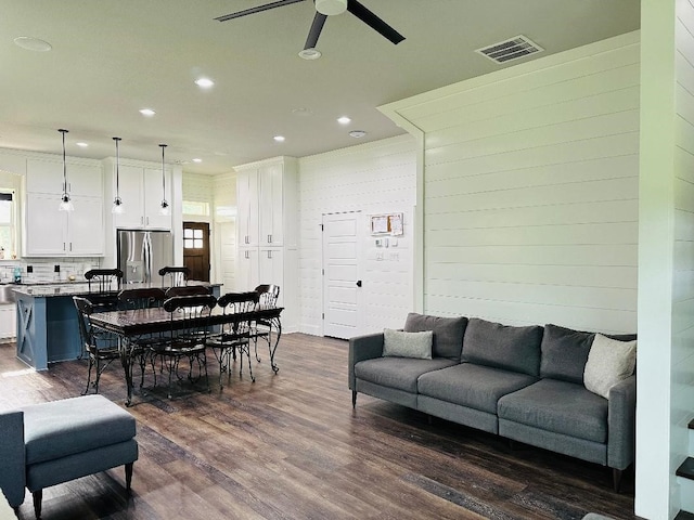 living room with dark hardwood / wood-style floors and ceiling fan