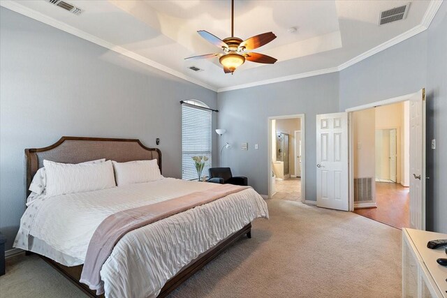 carpeted bedroom featuring ornamental molding, ensuite bathroom, ceiling fan, and a raised ceiling