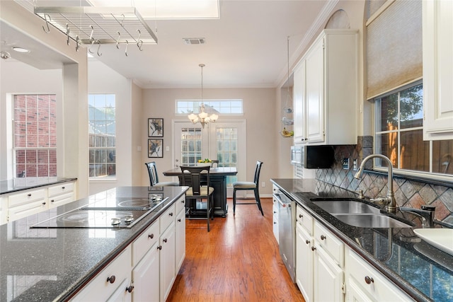 kitchen featuring pendant lighting, visible vents, white cabinetry, a sink, and wood finished floors