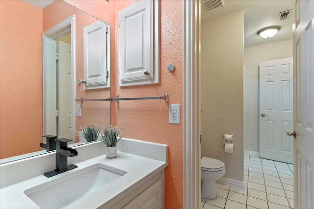 bathroom with vanity, toilet, and tile patterned flooring