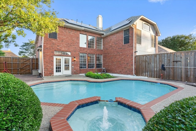 view of pool featuring a patio area, an in ground hot tub, and french doors