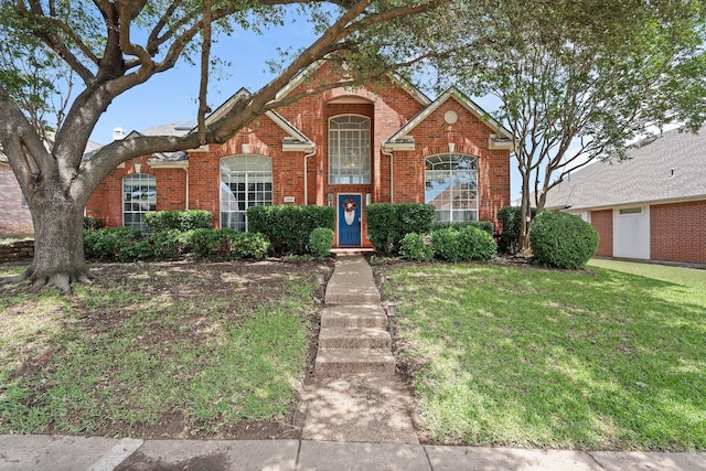 traditional-style house featuring brick siding and a front lawn