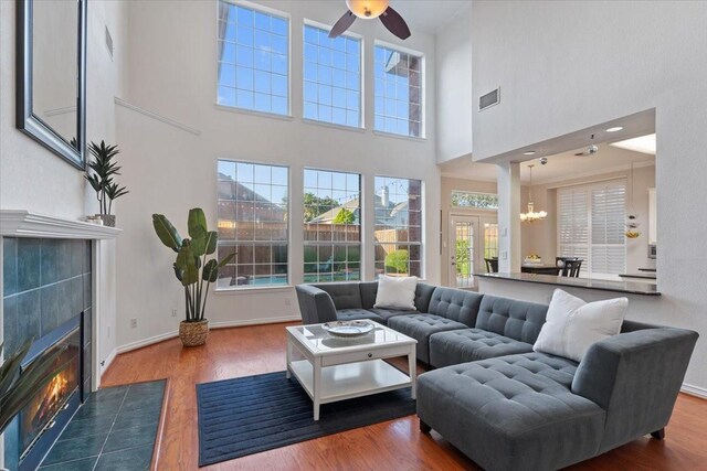 entrance foyer featuring ornamental molding, an inviting chandelier, wood-type flooring, and plenty of natural light