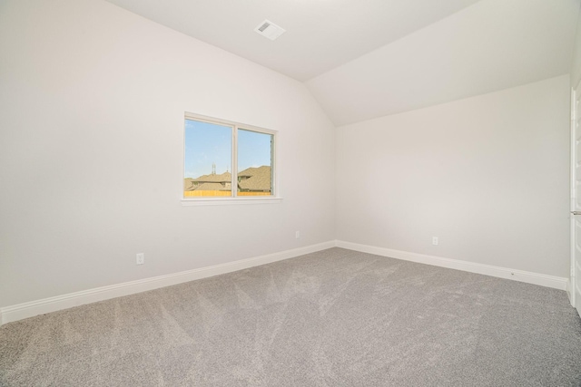 unfurnished room featuring lofted ceiling and carpet floors