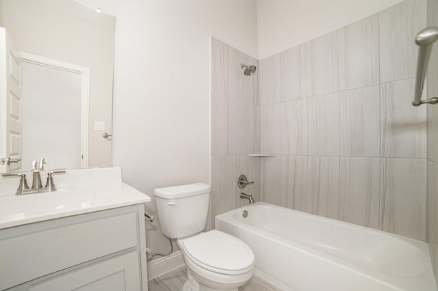 full bathroom with toilet, vanity, and tiled shower / bath