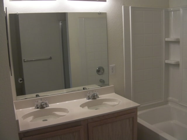 bathroom featuring bathing tub / shower combination and double sink vanity