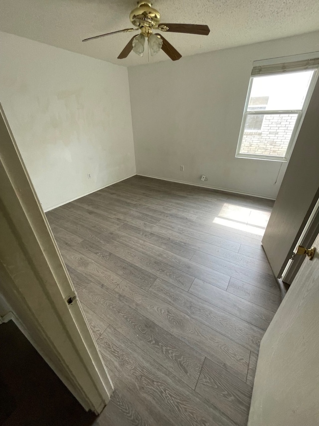 empty room featuring hardwood / wood-style flooring, a textured ceiling, and ceiling fan