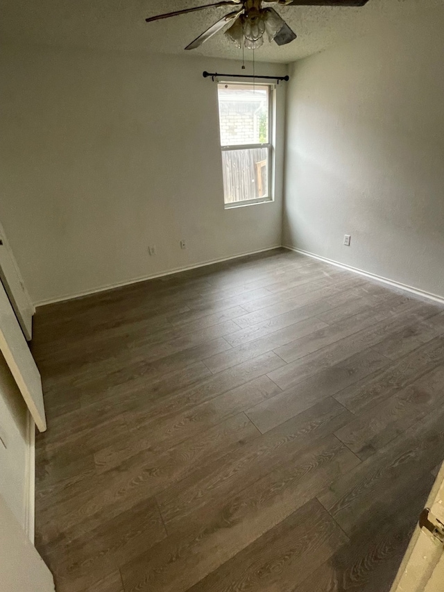 empty room featuring dark hardwood / wood-style flooring and ceiling fan