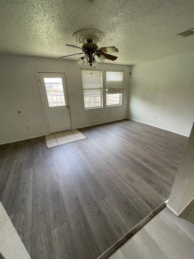 unfurnished room with hardwood / wood-style flooring, a textured ceiling, and ceiling fan