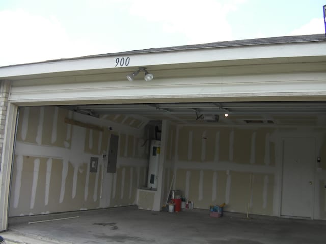 garage with electric water heater and electric panel