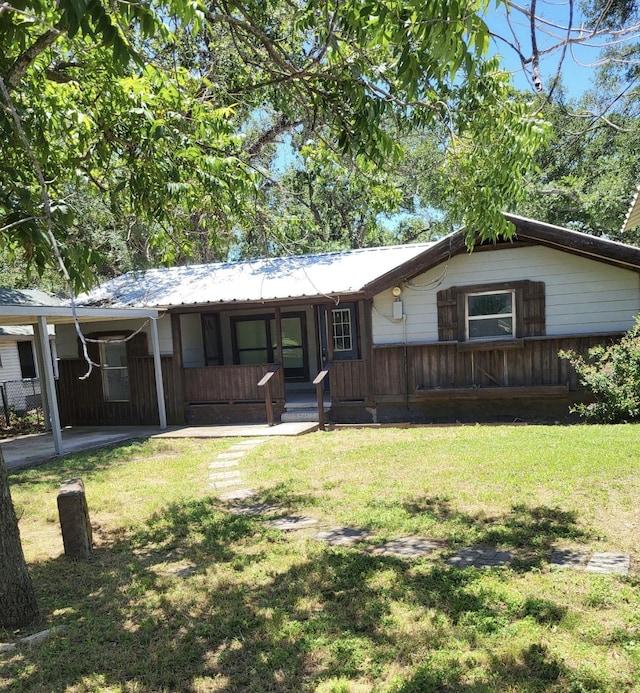 ranch-style home with covered porch and a front yard