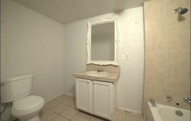 full bathroom featuring tile patterned flooring, vanity, toilet, and tiled shower / bath