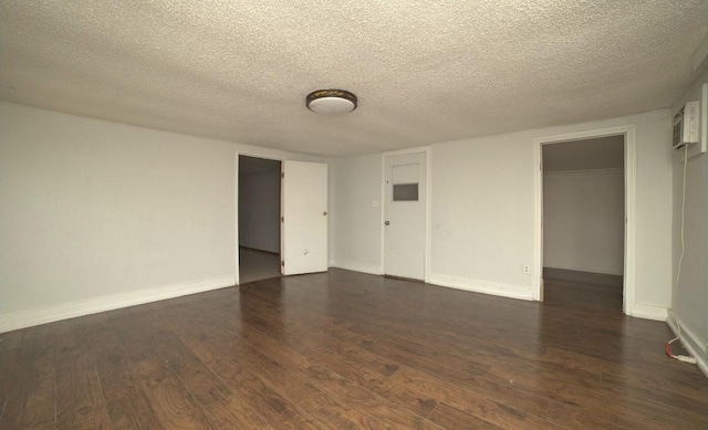 unfurnished room with dark wood-type flooring and a textured ceiling