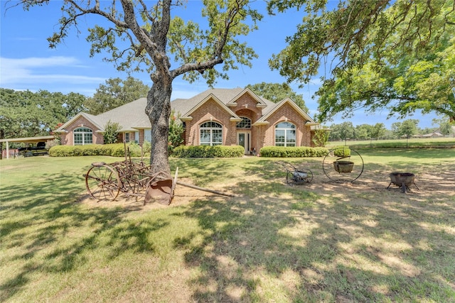 ranch-style house featuring a front yard and an outdoor fire pit