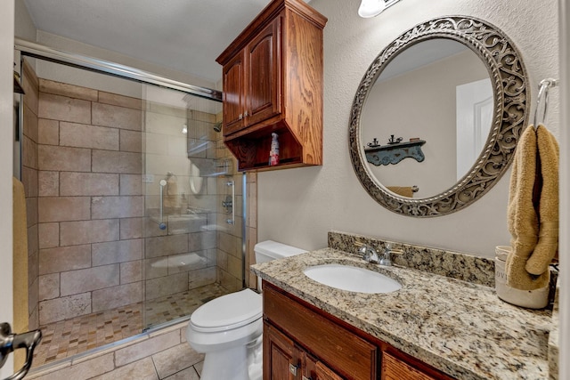 bathroom featuring tile patterned floors, vanity, toilet, and walk in shower