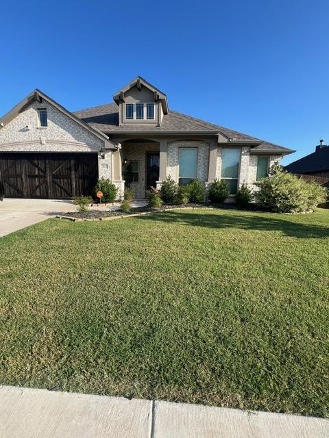 view of front facade featuring a front yard and a garage