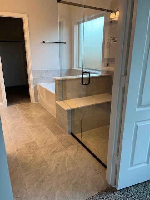 bathroom featuring tile patterned flooring and plus walk in shower