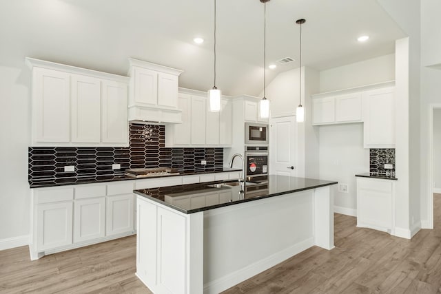 kitchen with visible vents, dark countertops, light wood-style flooring, stainless steel oven, and white cabinetry