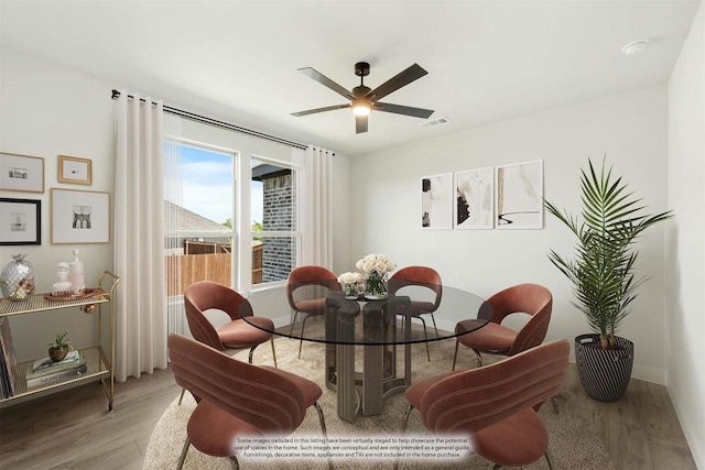 dining space featuring ceiling fan, light wood finished floors, and visible vents