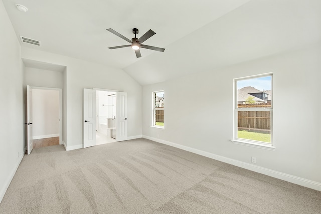 unfurnished bedroom featuring vaulted ceiling, light carpet, and ceiling fan