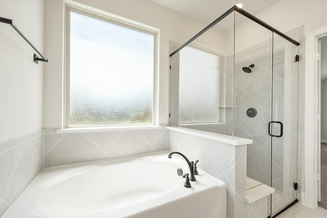 full bathroom with a shower stall and a bath