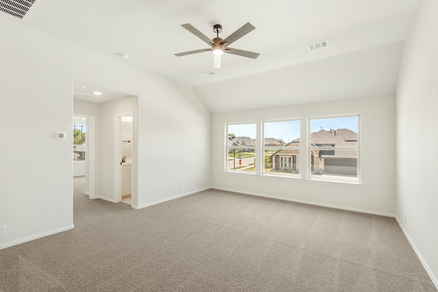 spare room featuring lofted ceiling, ceiling fan, and light carpet