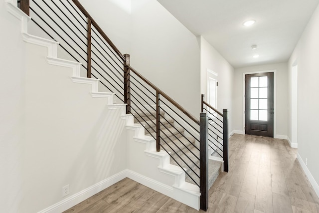 foyer entrance with stairs, recessed lighting, light wood-type flooring, and baseboards