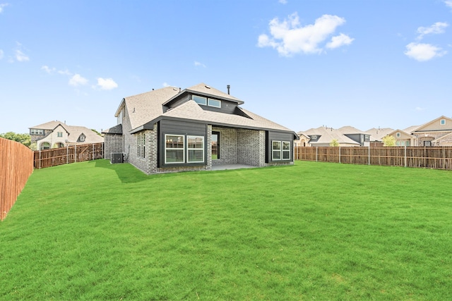 back of property with a patio area, a fenced backyard, a lawn, and brick siding