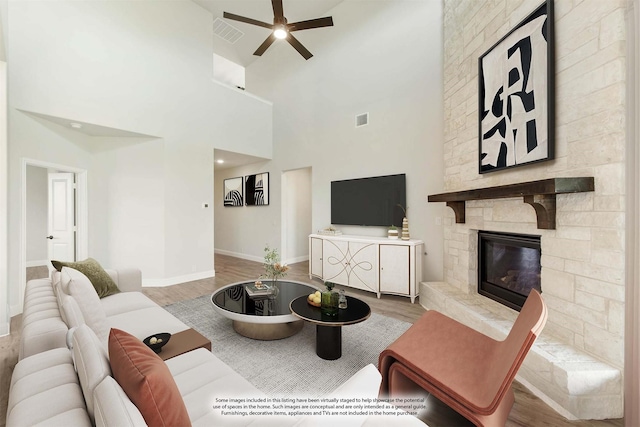 living area with baseboards, visible vents, a fireplace, and light wood finished floors