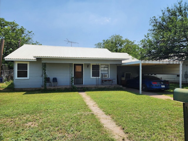ranch-style home with covered porch, an attached carport, metal roof, and a front yard