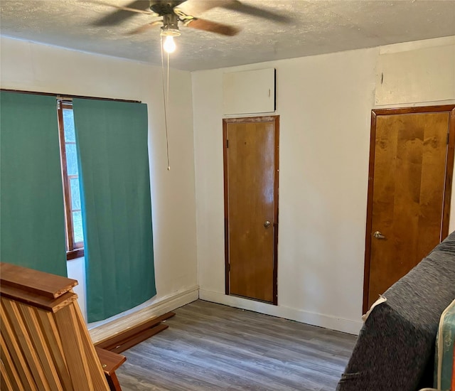 interior space featuring wood-type flooring, ceiling fan, and a textured ceiling