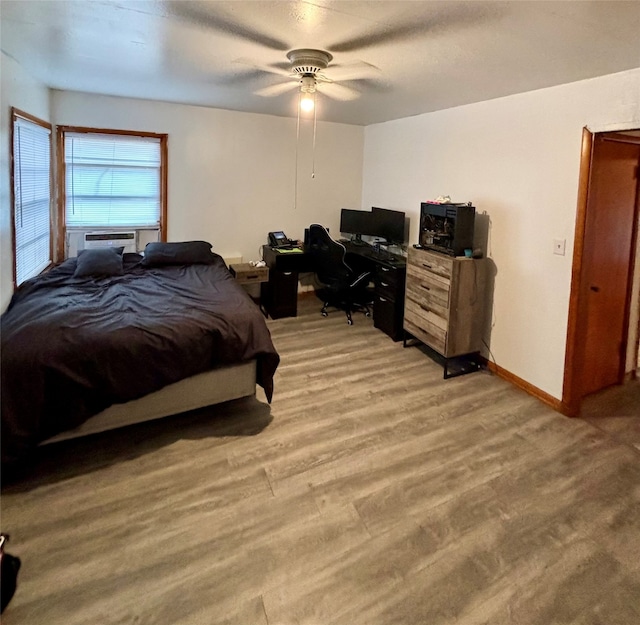 bedroom featuring light wood-type flooring, cooling unit, and ceiling fan