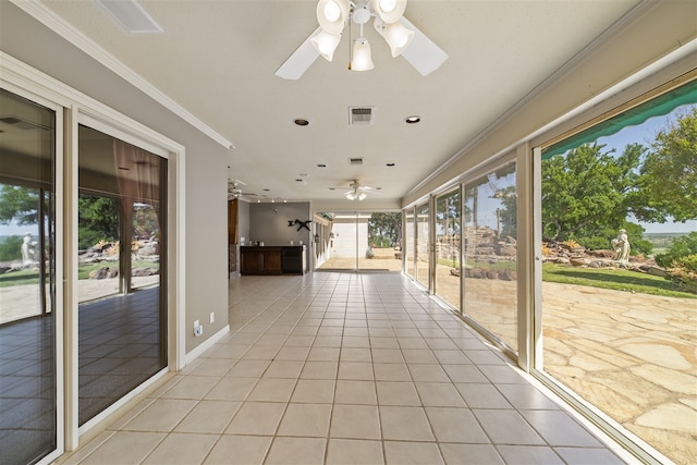 unfurnished sunroom featuring ceiling fan