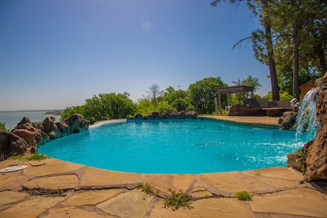 view of swimming pool featuring a pergola, pool water feature, and a water view