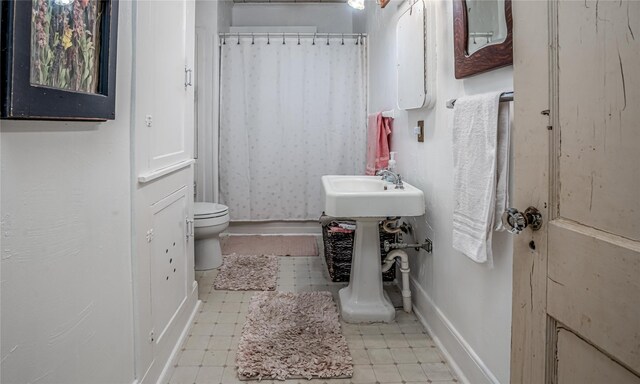 bathroom with toilet and curtained shower