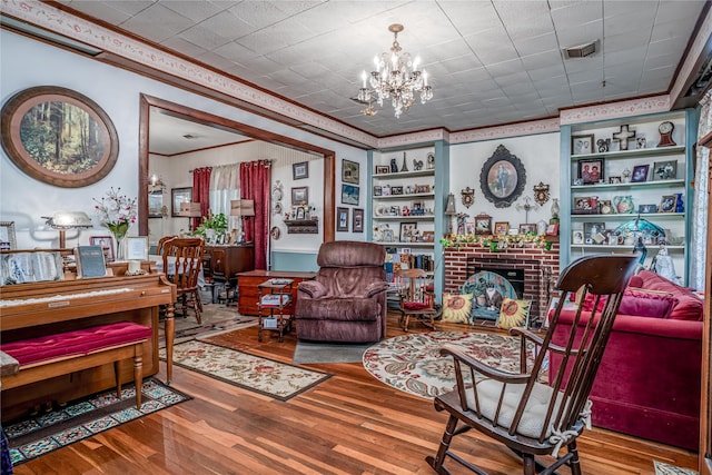 2252 Cleveland St, Paris, TX 75460 - living area featuring crown molding, a chandelier, wood finished floors, built in shelves, and a brick fireplace