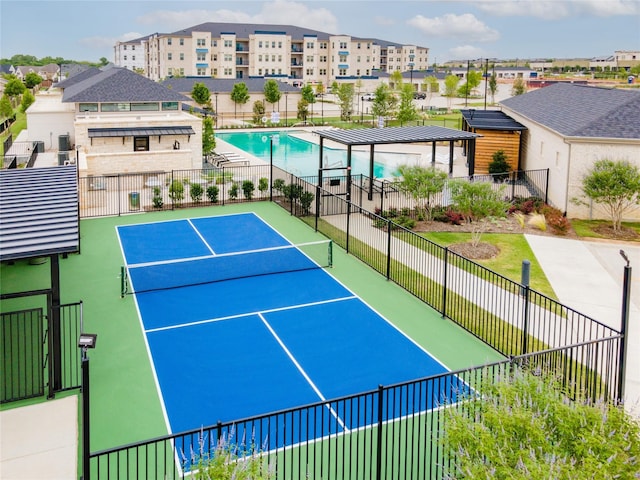 view of tennis court featuring a fenced in pool