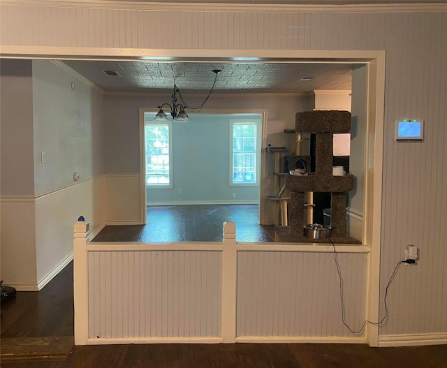 kitchen featuring ornamental molding, dark wood-type flooring, and an inviting chandelier