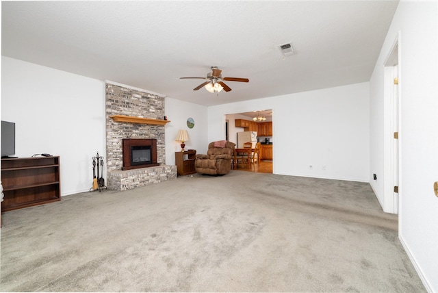 living room with a fireplace, carpet flooring, and ceiling fan