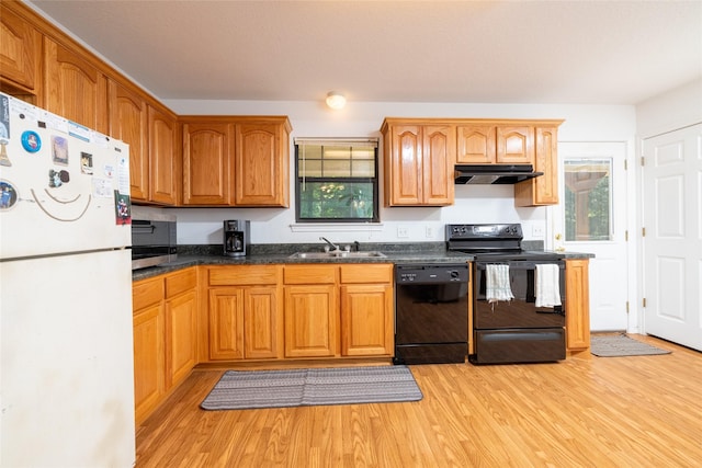 kitchen featuring black appliances, light wood-type flooring, and sink