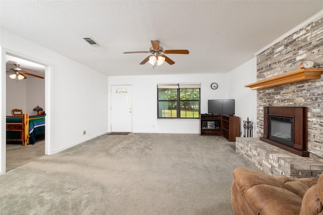 carpeted living room featuring a textured ceiling, a brick fireplace, and ceiling fan