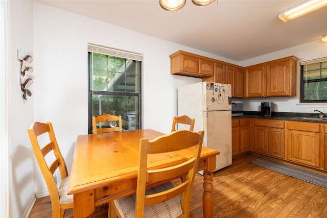 kitchen with white refrigerator, sink, and light hardwood / wood-style flooring