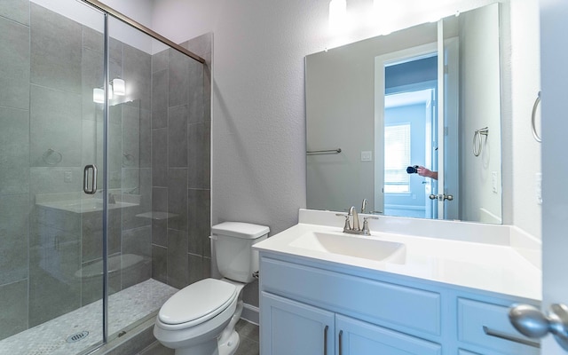 bathroom featuring an enclosed shower, oversized vanity, toilet, and tile floors