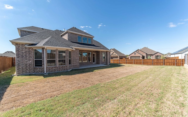 rear view of house with a patio and a yard