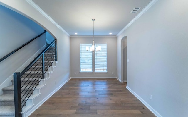 unfurnished dining area featuring wood finished floors, arched walkways, visible vents, and ornamental molding